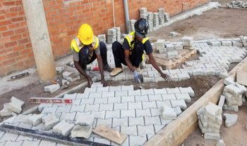 a couple of men laying bricks