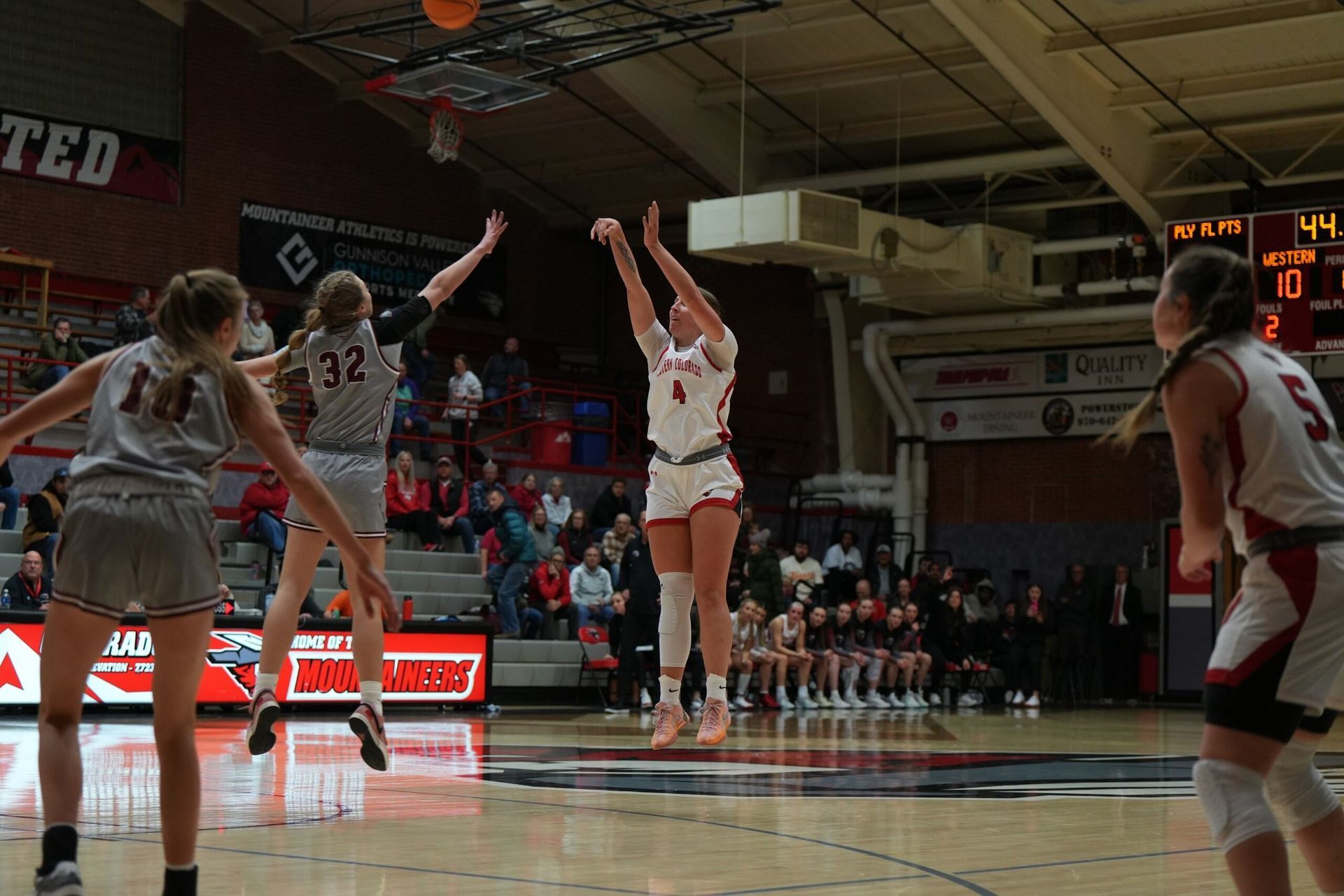 A group of girls are playing basketball on a court.