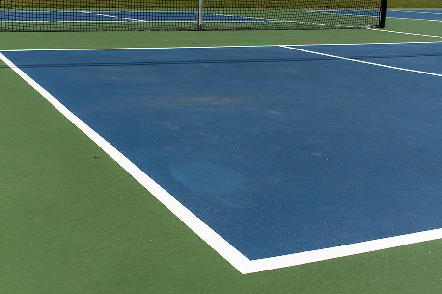 A blue and green tennis court with a white line