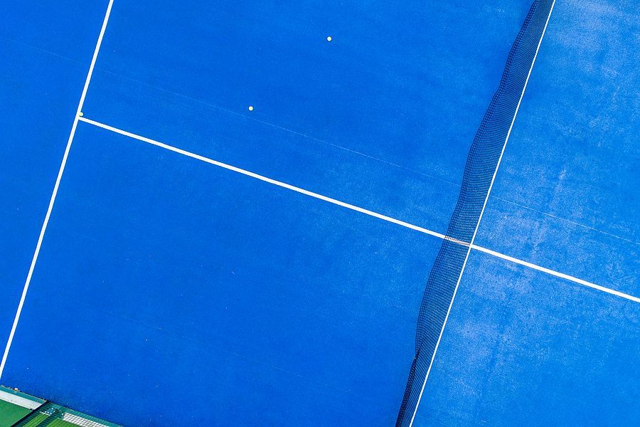 An aerial view of a blue tennis court with white lines