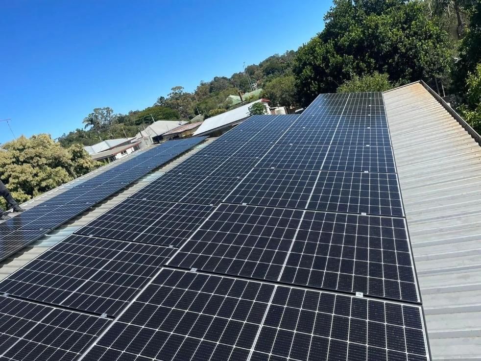 Solar Panels Installed on a Metal Roof, Reflecting Sunlight — KACE Electrical Solutions In Ramsay, QLD