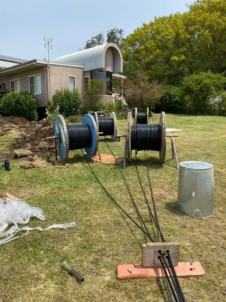 Cable Spools in a Yard With a House in the Background — KACE Electrical Solutions In Ramsay, QLD