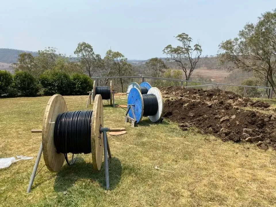 Cable Spools on Grass Near a Ditch — KACE Electrical Solutions In Ramsay, QLD