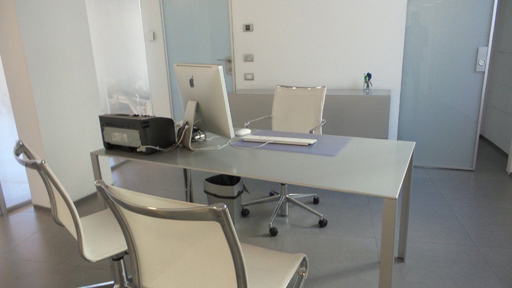 Studio medico con pc e sedie bianche