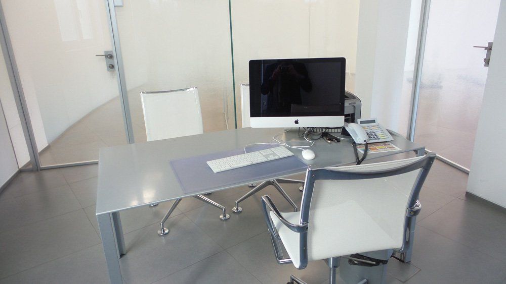 Studio medico con computer e sedie bianche