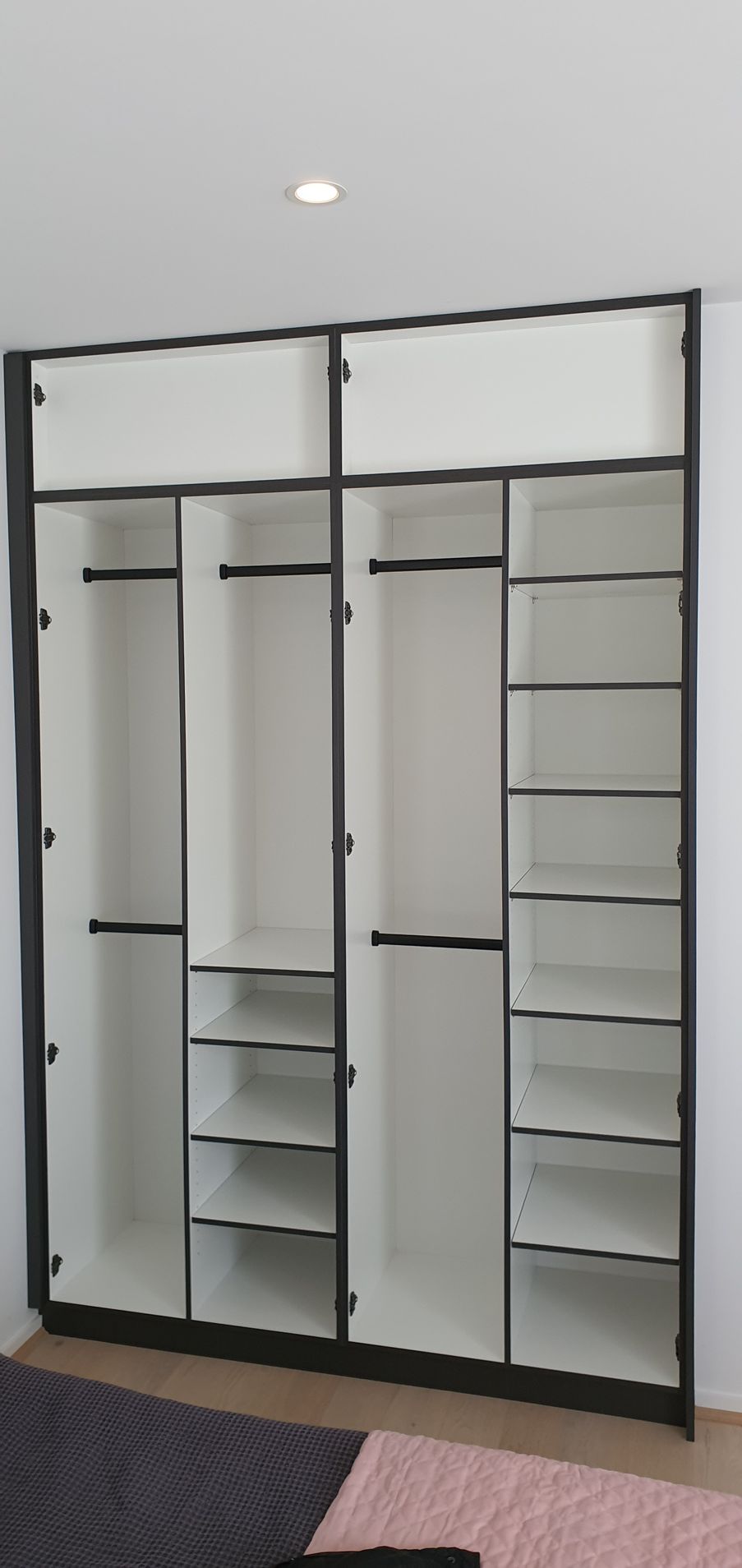 A large empty wardrobe with lots of shelves in a room