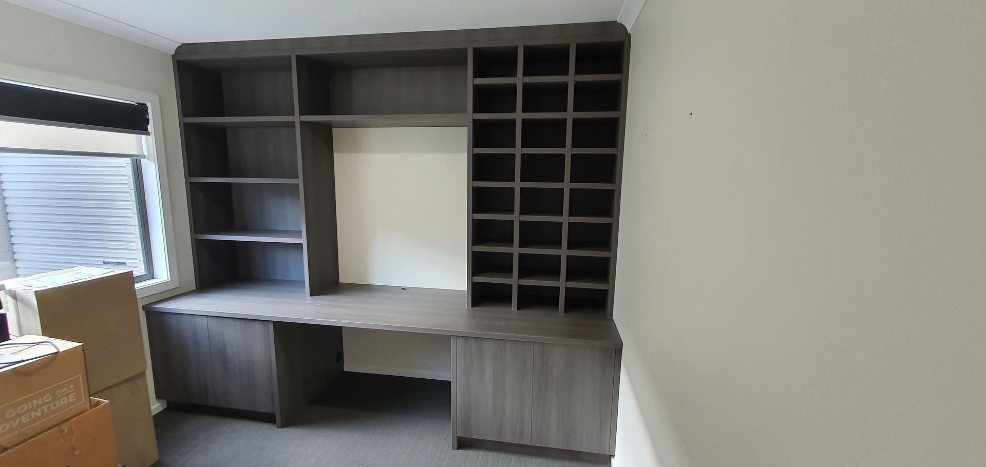 A room with a desk and shelves in it.