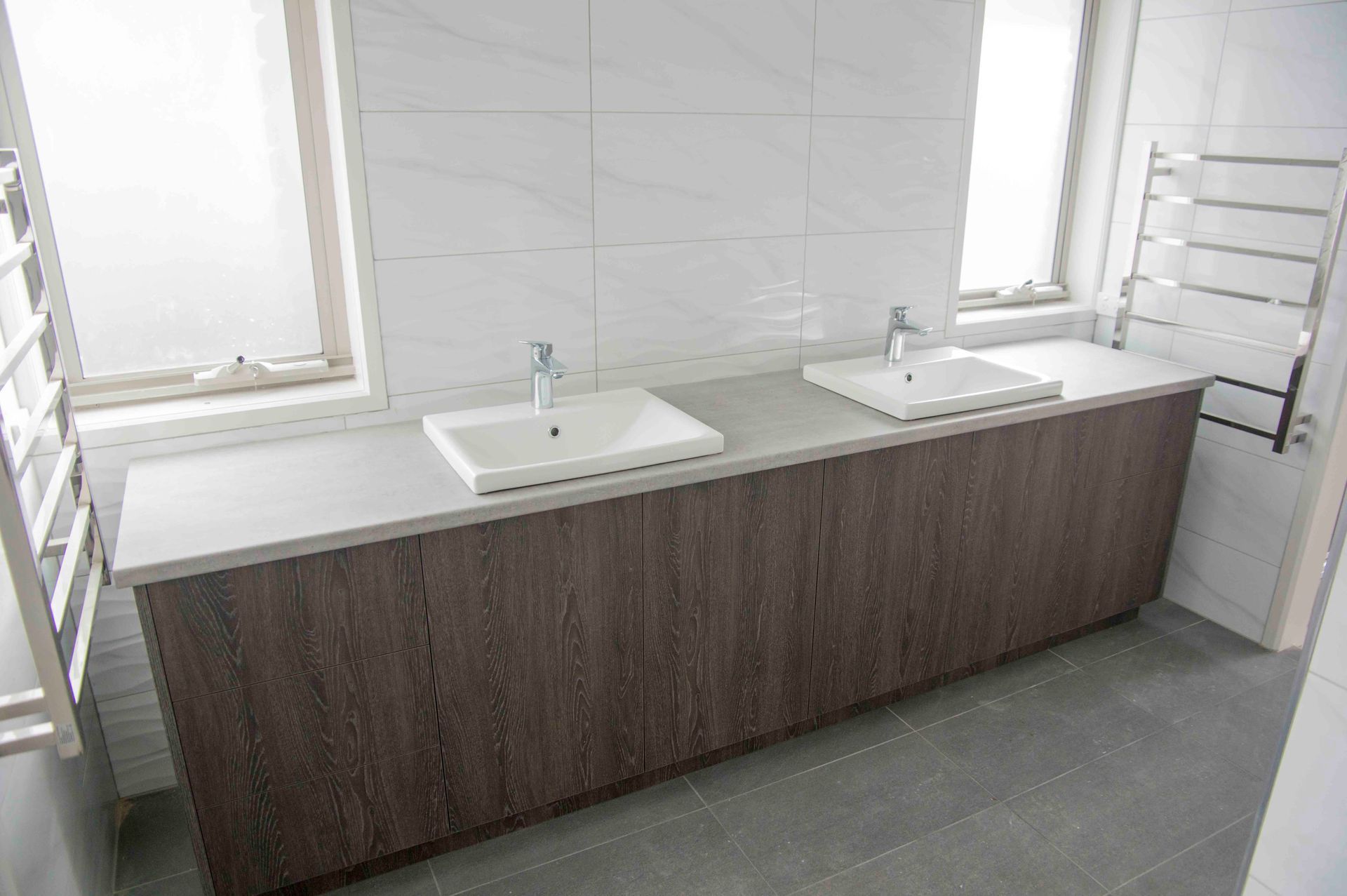 A bathroom with two sinks and a window.