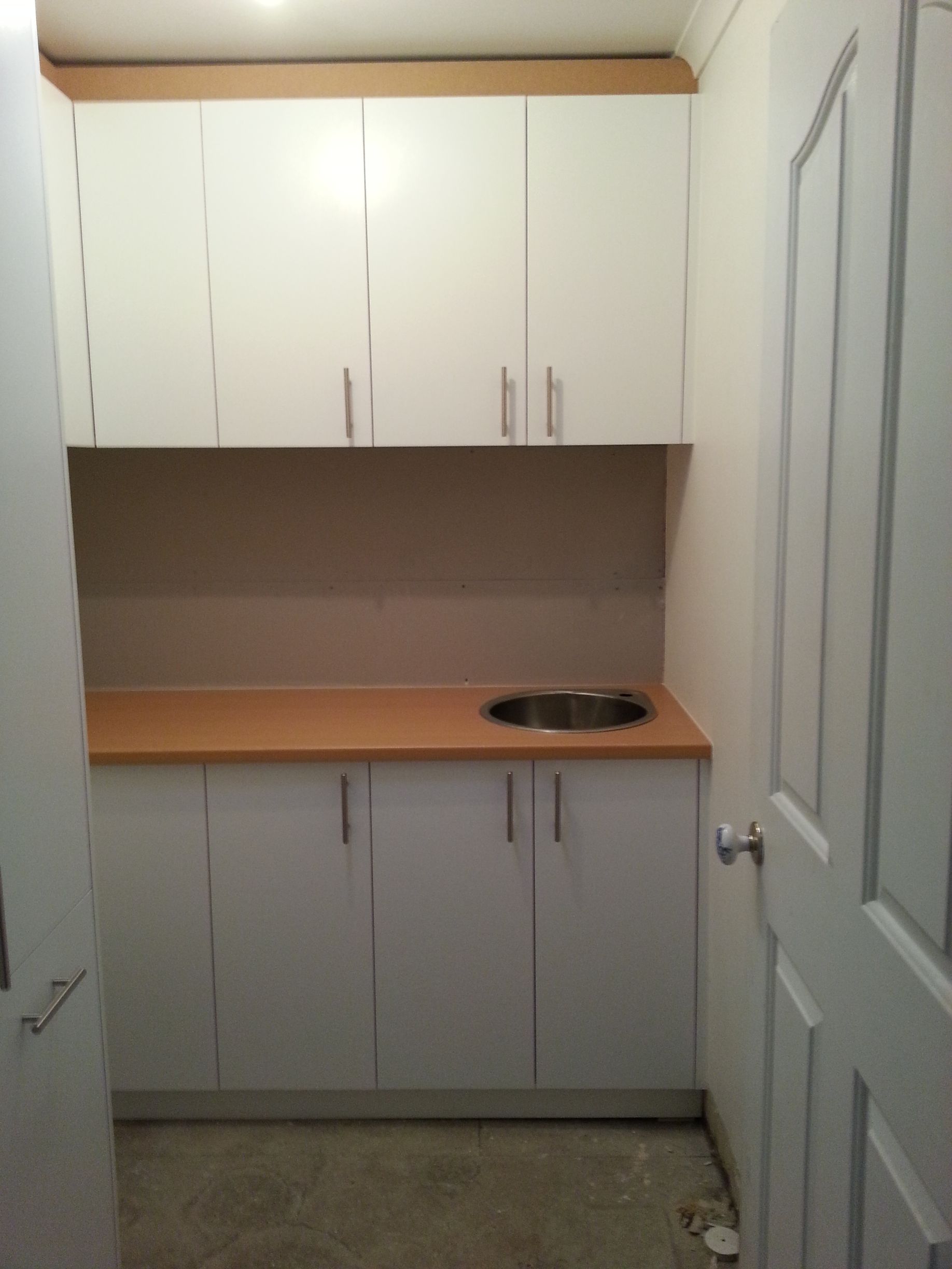 A small kitchen with white cabinets and a sink