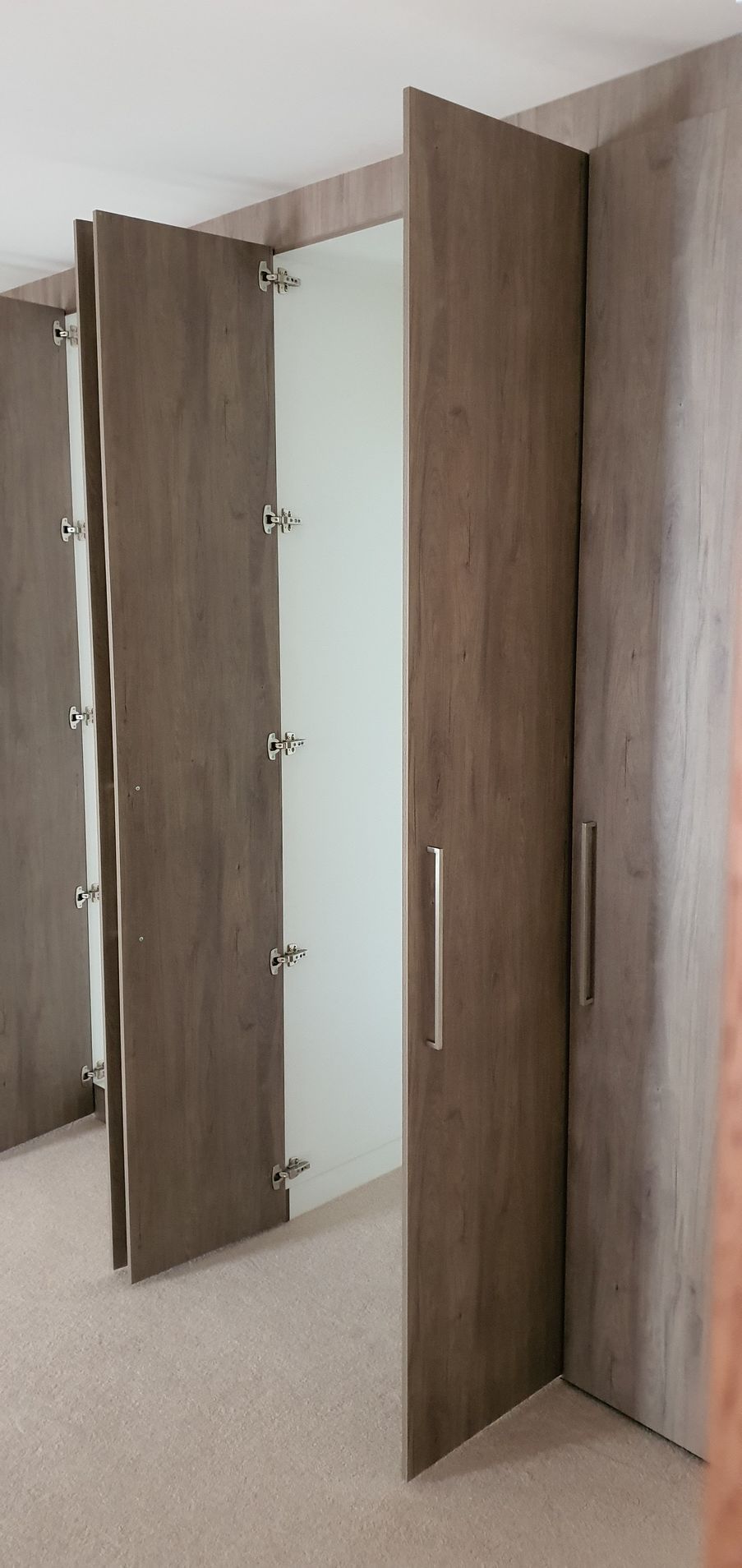 A close up of a wooden door in a room with a mirror.