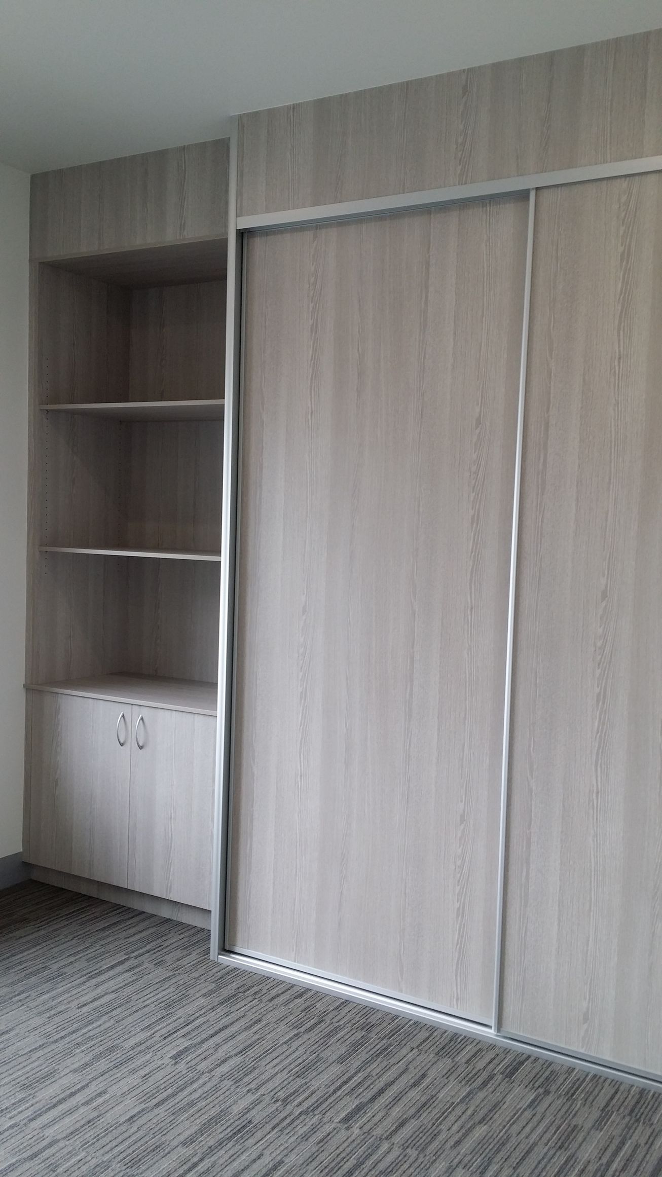 A room with sliding doors and shelves in it.