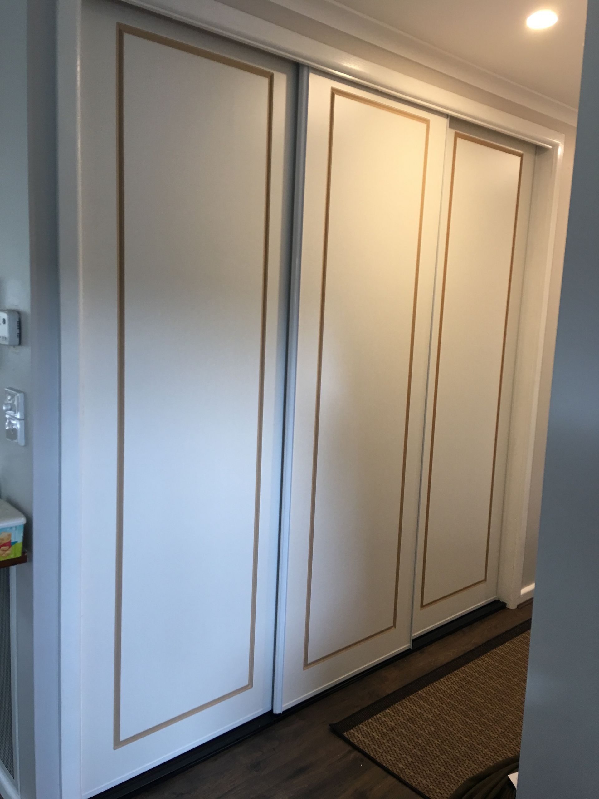 A hallway with sliding doors and a rug on the floor