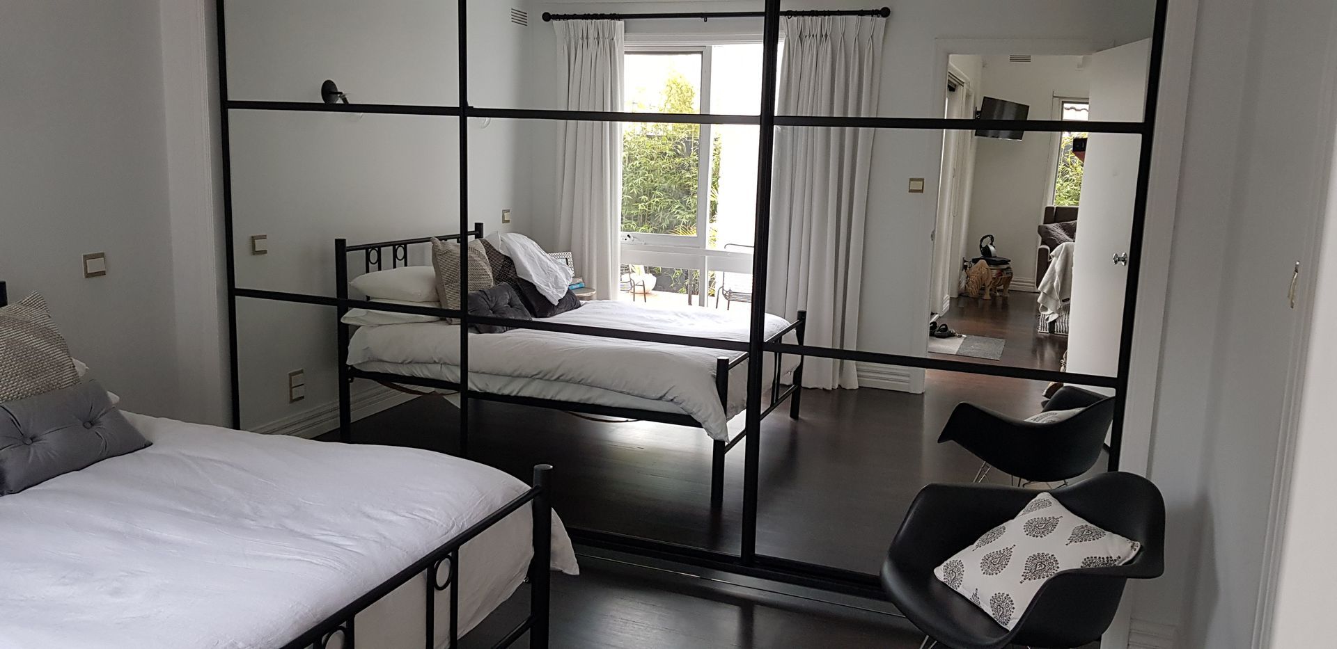 A bedroom with a bed , chair and sliding glass doors.