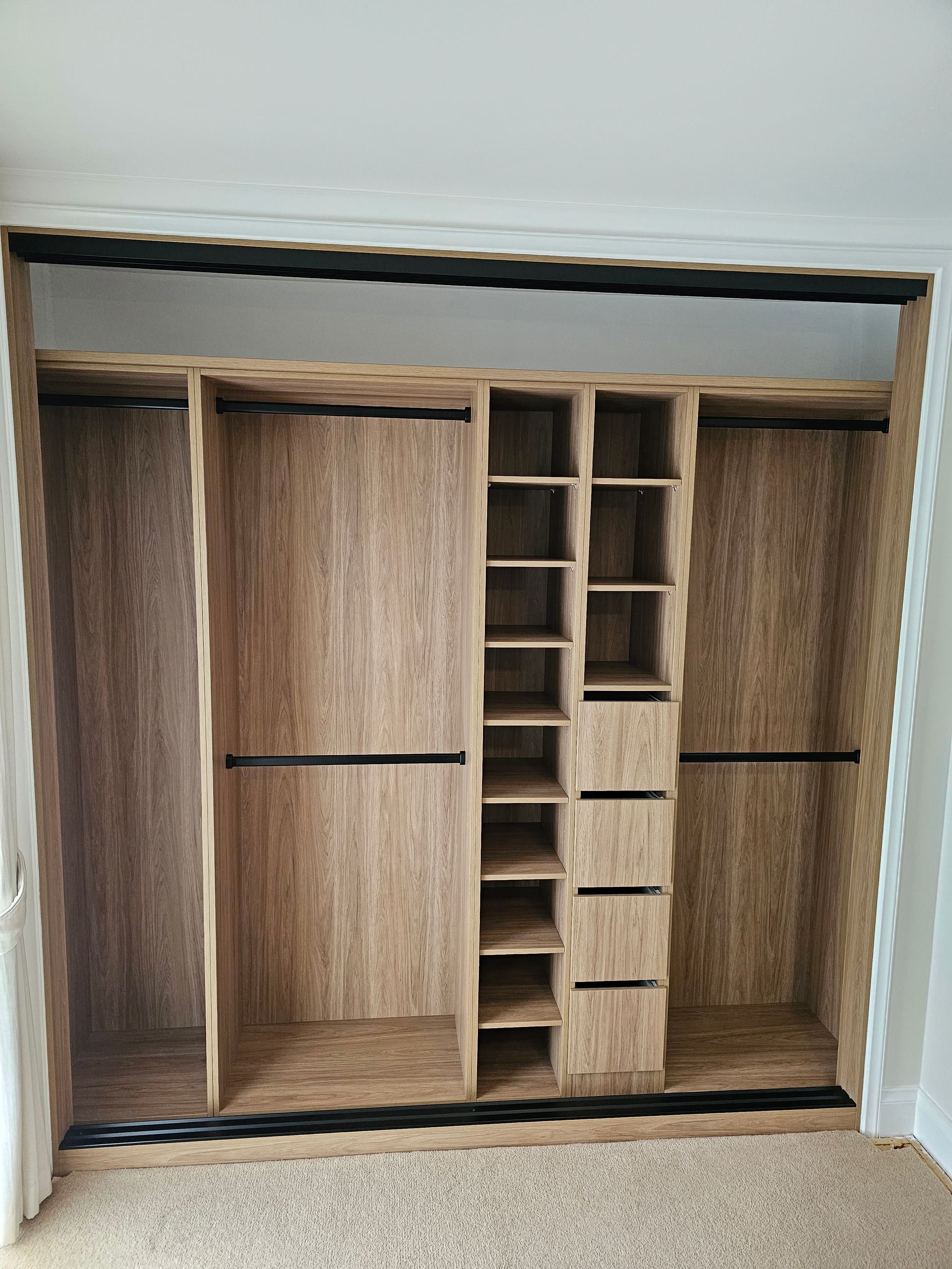 A large wooden closet with lots of shelves and drawers