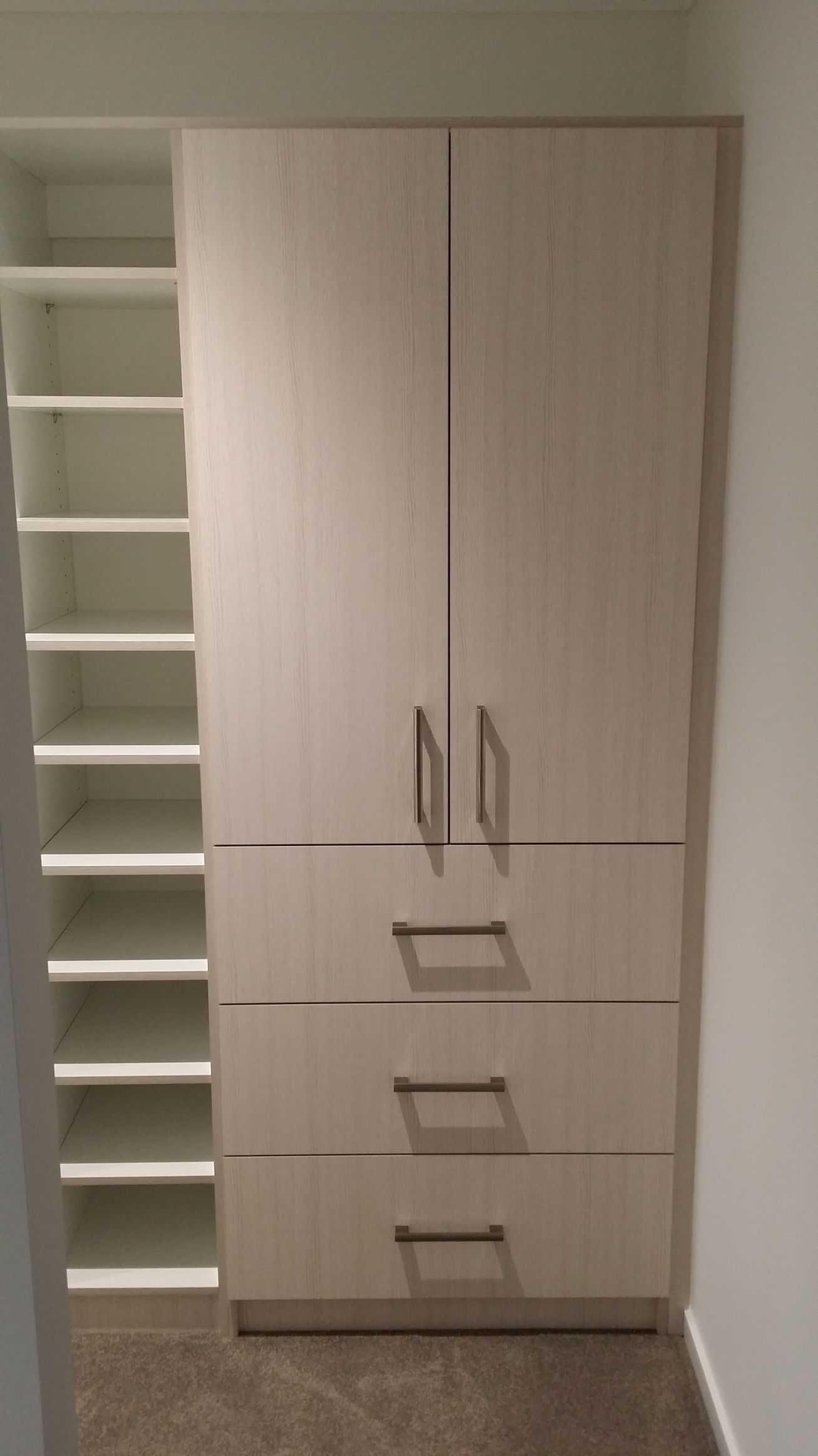 A closet with shelves and drawers in a room.