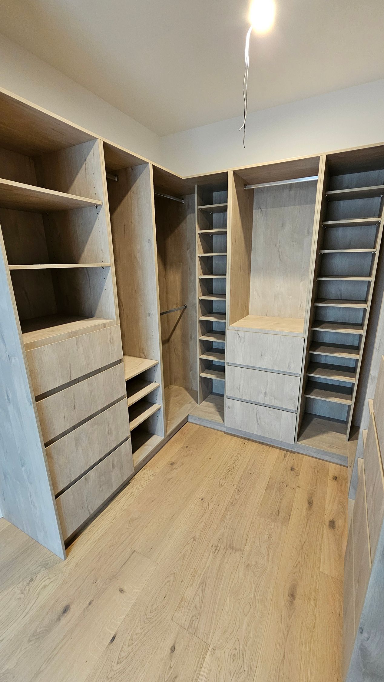 A walk in closet with lots of shelves and drawers.