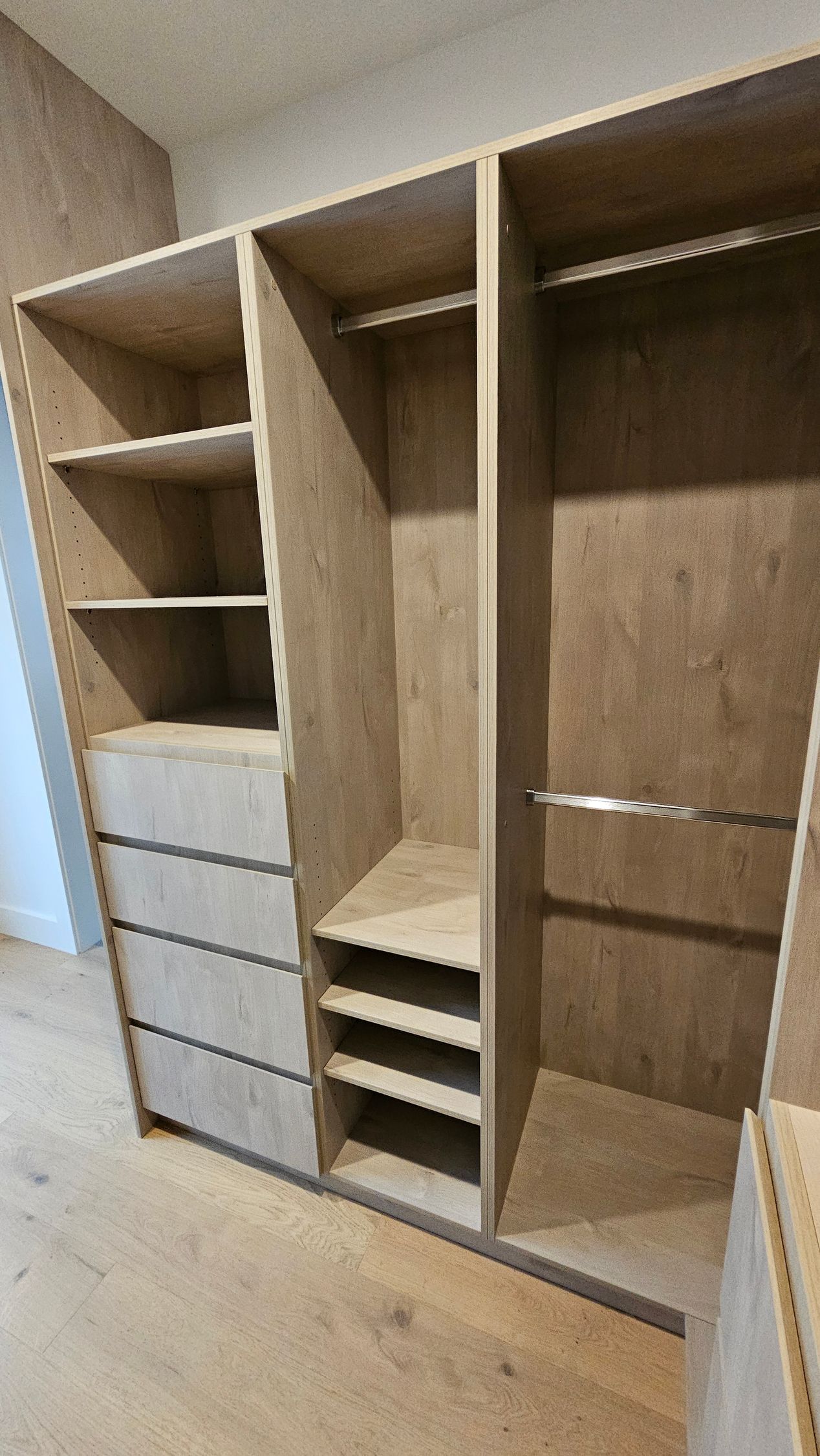 A walk in closet with lots of shelves and drawers.