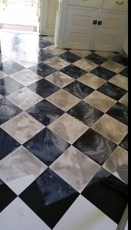 A floor with a diagonal black-and-white checkered pattern, transitioning to plain white tiles in the foreground.