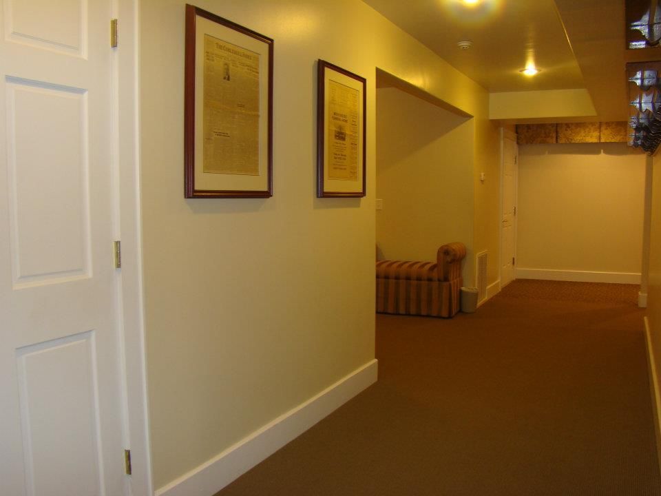 A hallway with two framed pictures on the wall