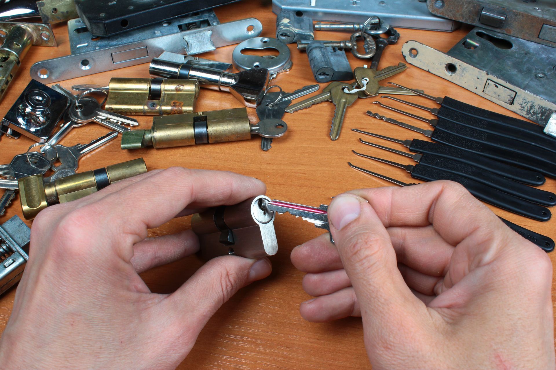 A locksmith adjusting a lock cylinder with tools on a bench. A locksmith adjusting a lock cylinder with tools on a bench.