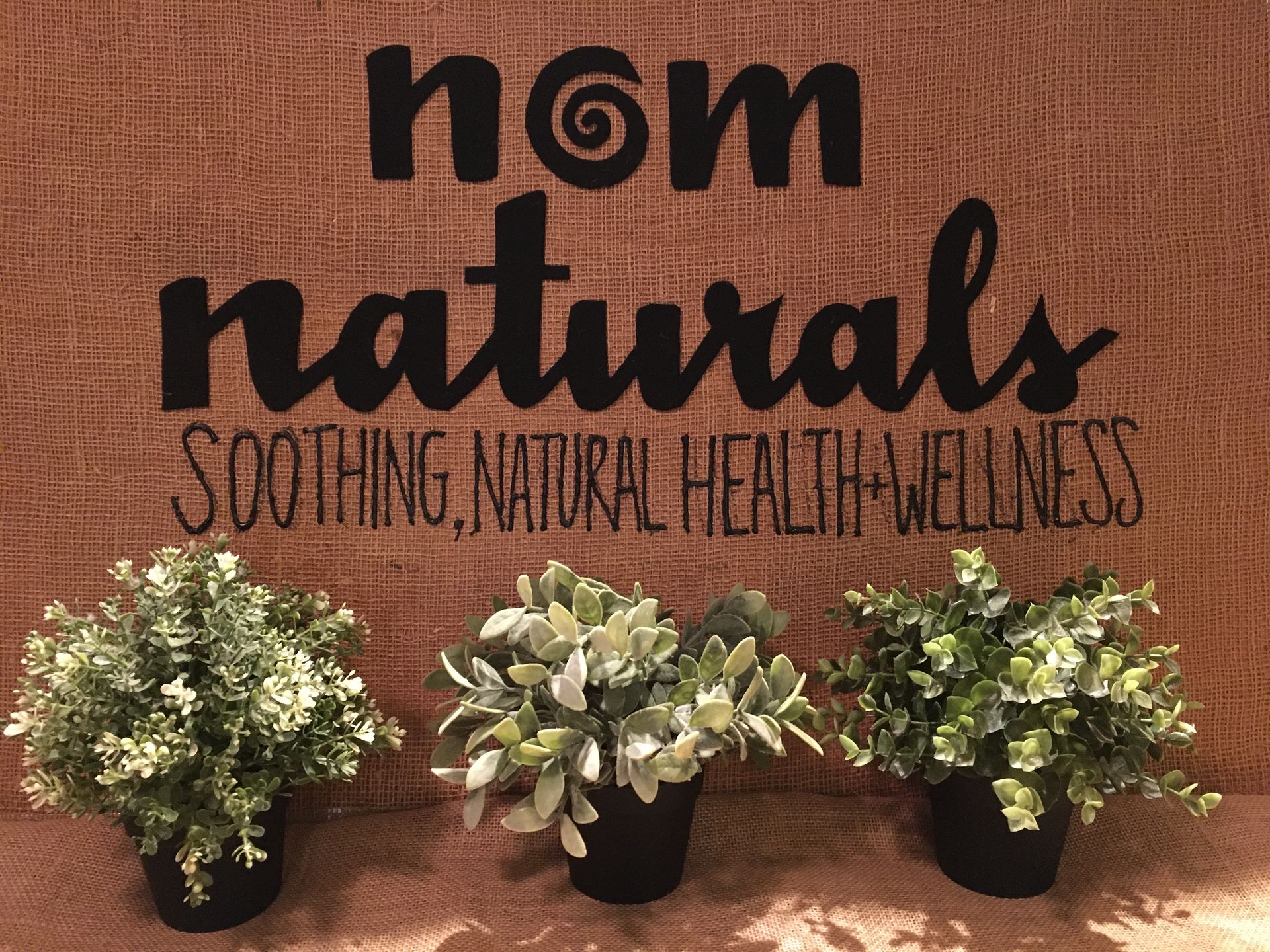 A sign that says nom naturals soothing natural health wellness