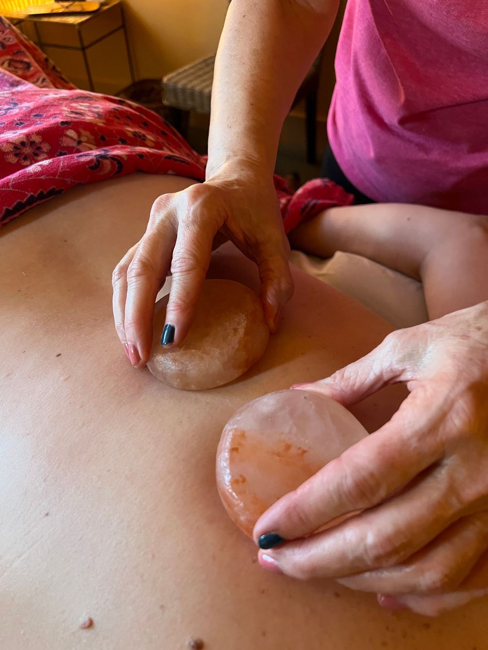 A person is getting a massage with a rock on their back