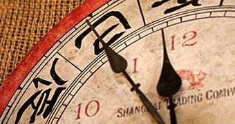 A close up of a clock with chinese writing on it
