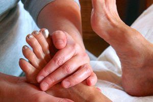 A person is giving a foot massage to another person.