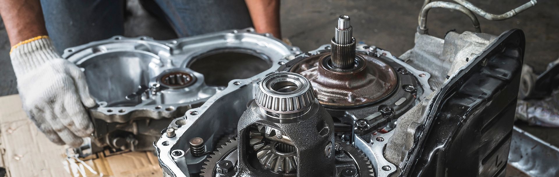 Gray automotive transmission with drive shaft attached.