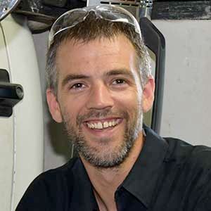 A man with a beard and sunglasses is smiling for the camera.