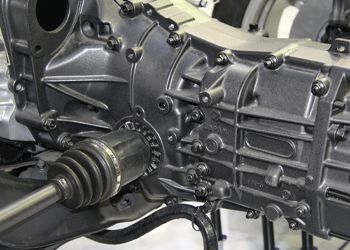 A close up of a car engine with a drive shaft.