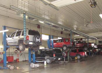 A jeep is sitting on a lift in a garage.