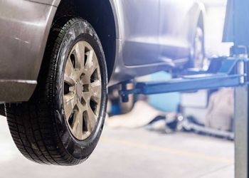 A car is sitting on a lift in a garage.