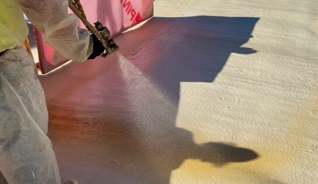 A roof with a chimney on top of it and trees in the background.