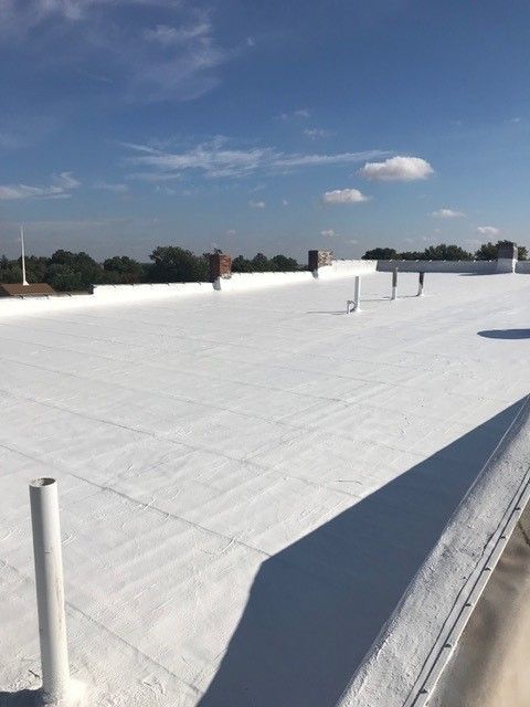 The roof of a building under construction with trees in the background