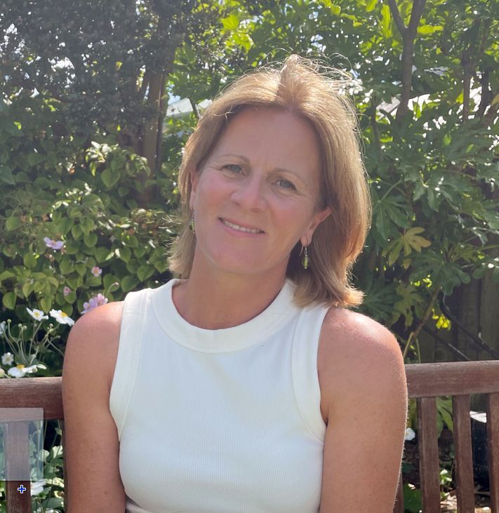 A woman in a white tank top is sitting on a bench