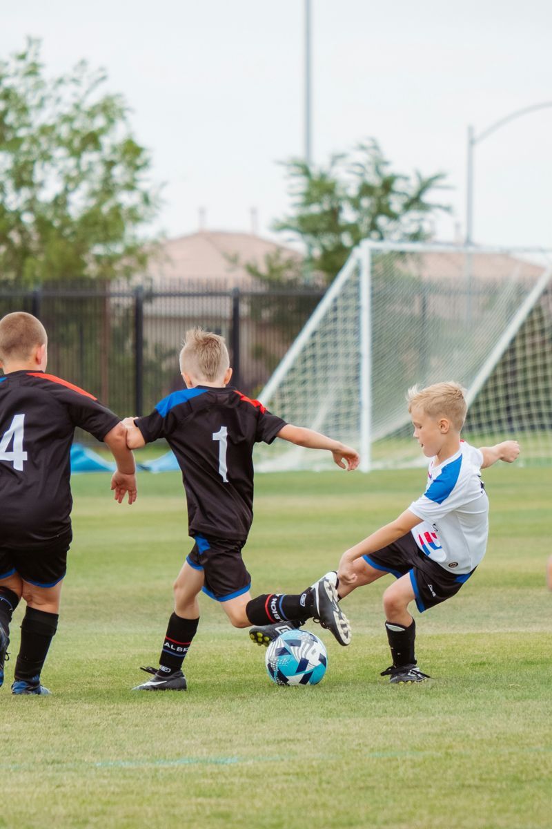 A group of young boys are playing soccer on a field.