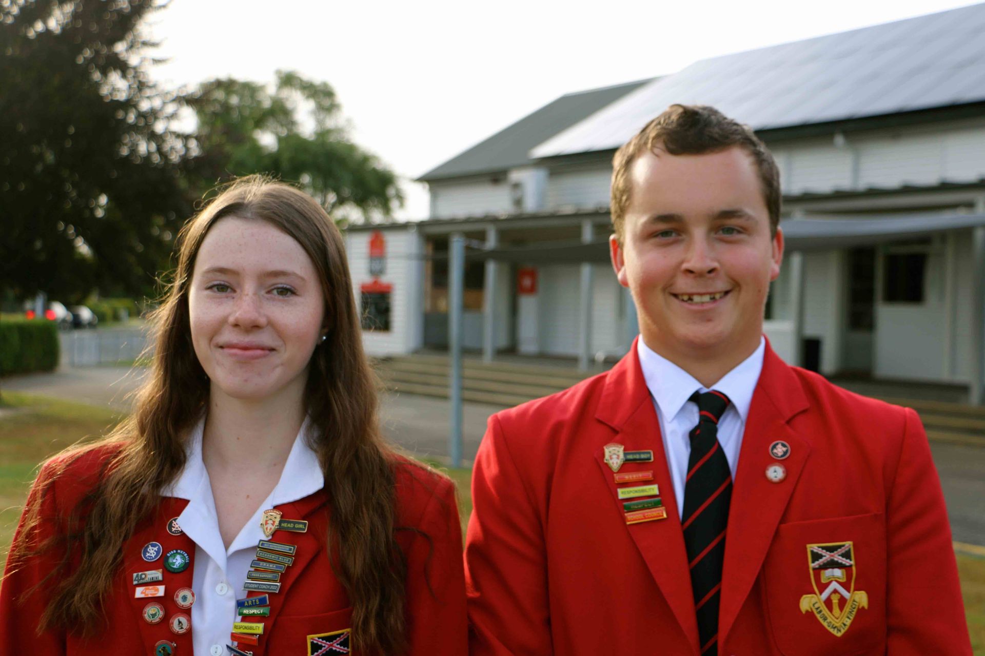 A man and a woman are standing next to each other in front of a building.