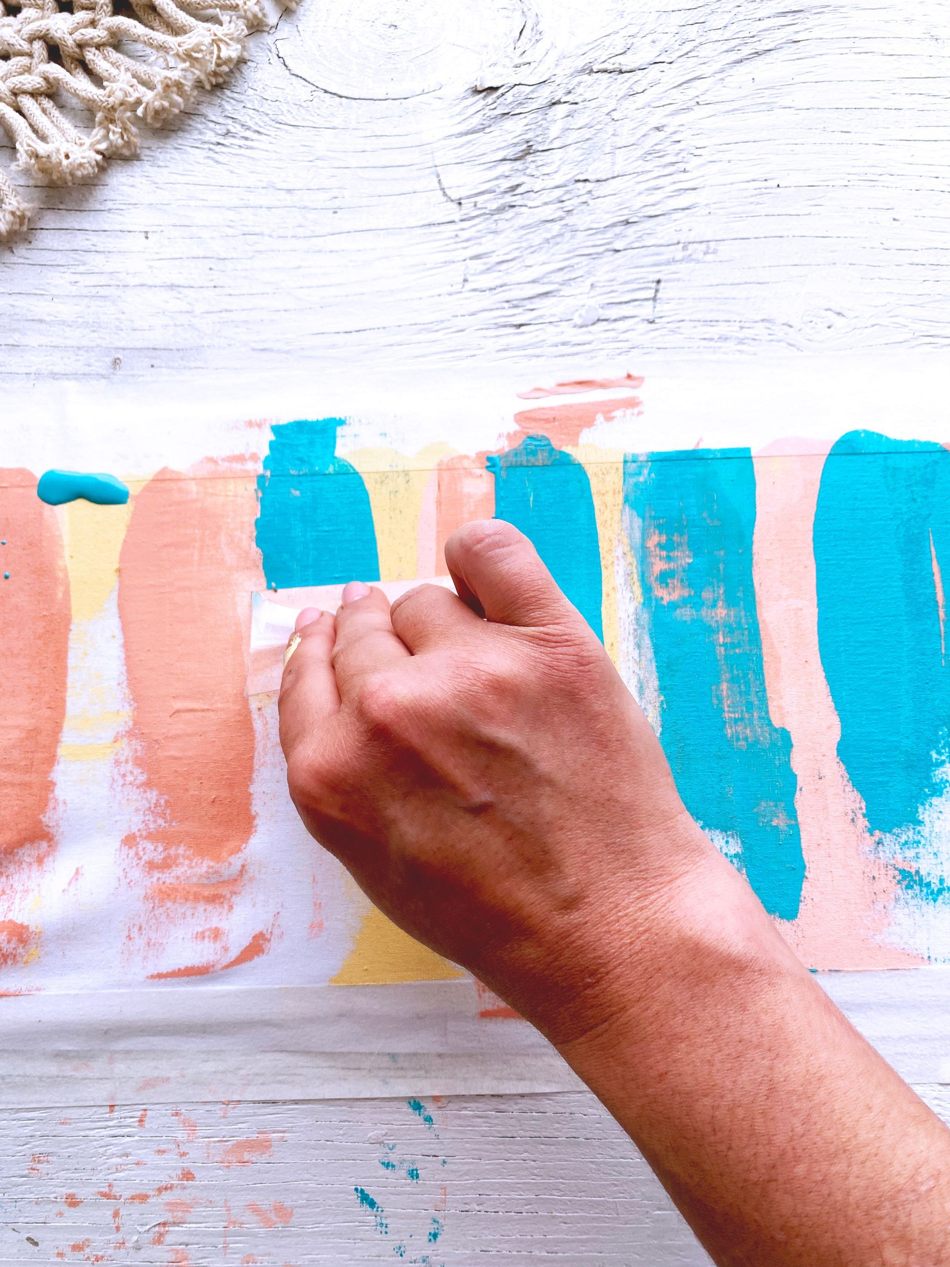 A close up of a person 's hand painting on a piece of paper.