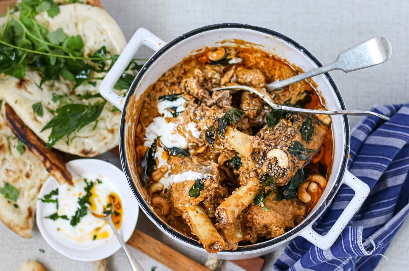 A pot of chicken curry with a spoon in it.