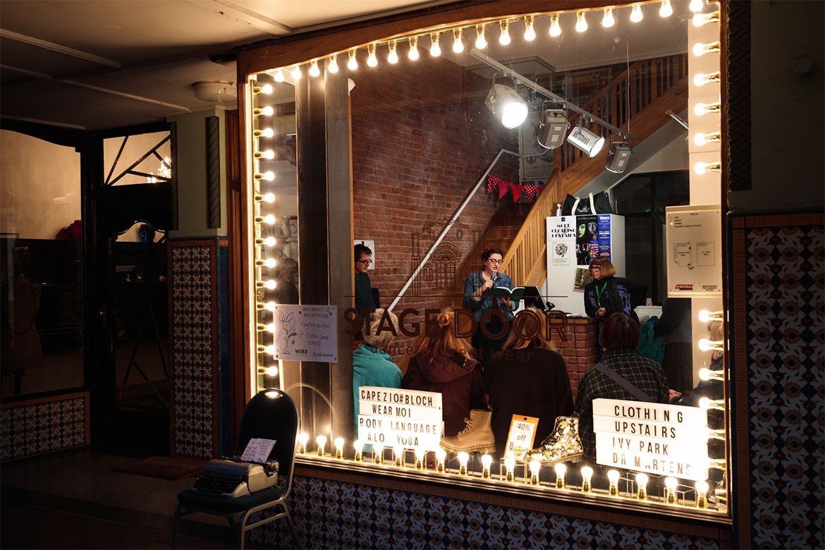 A group of people are sitting in front of a window with lights on it.