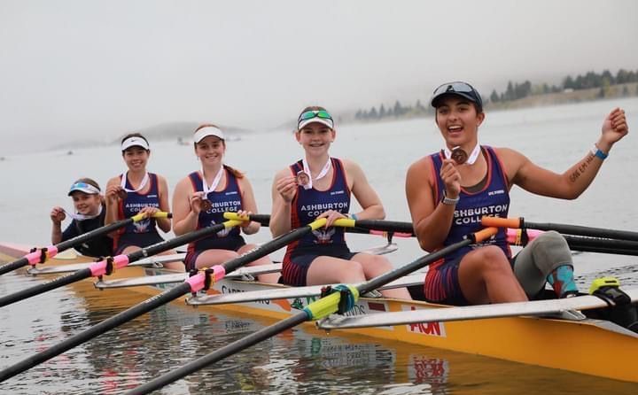 A group of people are rowing a boat in the water.