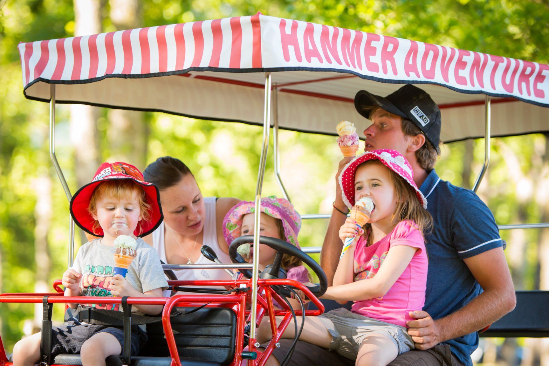 A family is riding in a hammer adventure wagon.