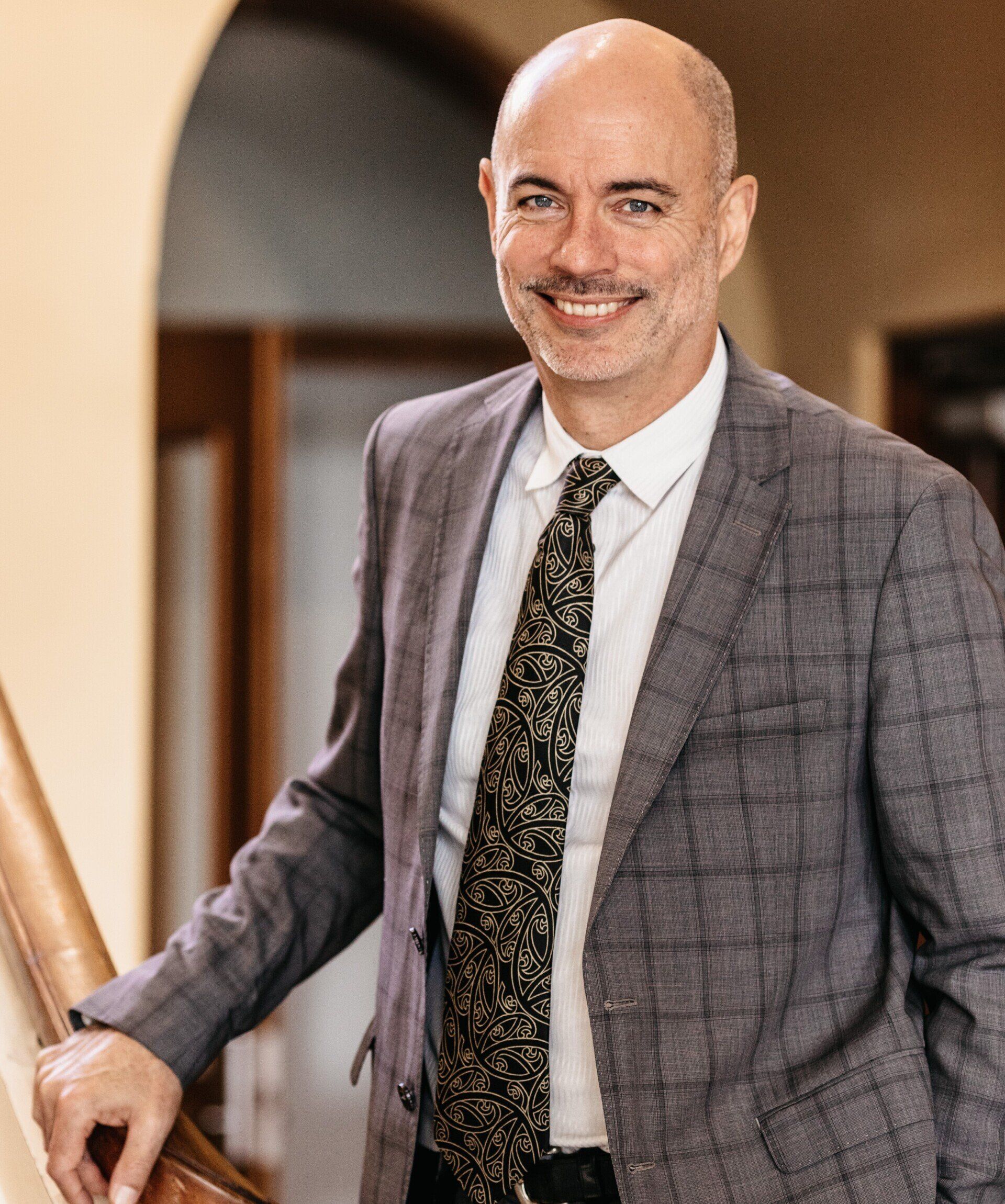 A man in a suit and tie is standing on a set of stairs.