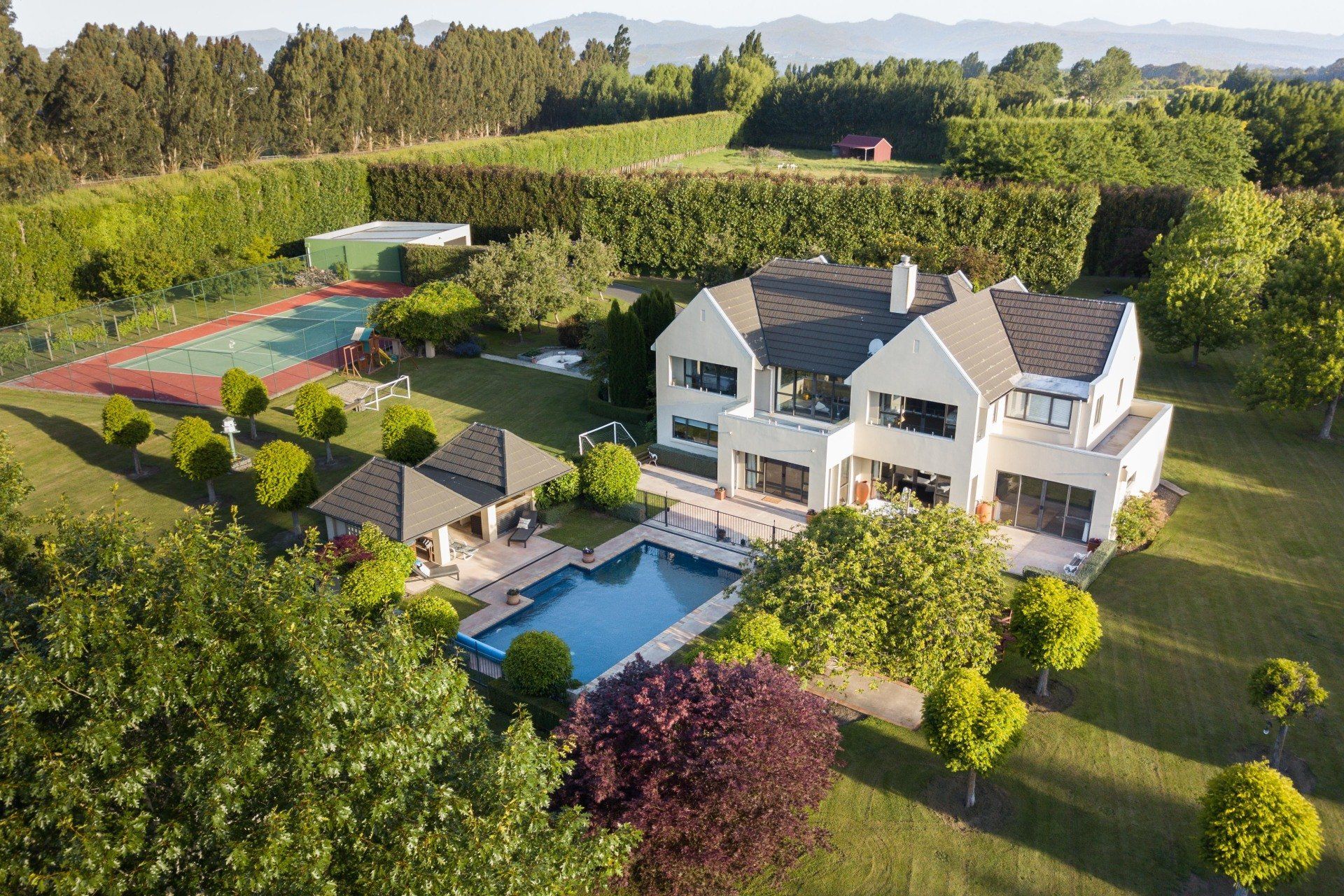 An aerial view of a large house with a swimming pool