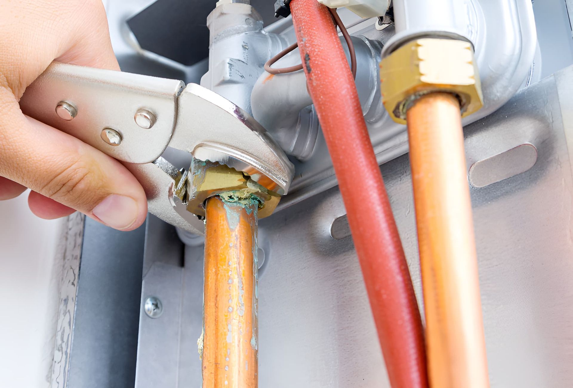 A Person is Fixing a Boiler With a Wrench — Simpson's Plumbing & Maintenance Service in Dakabin, QLD