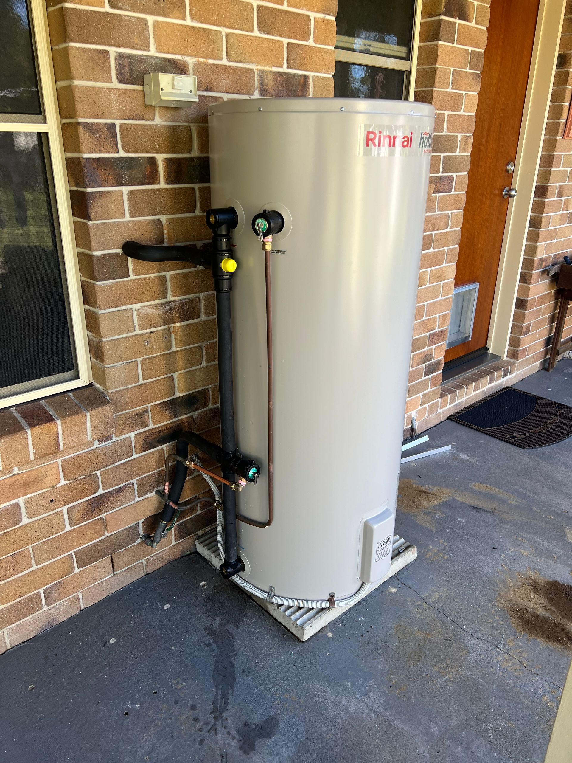 A Water Heater is Attached to a Wall in a Bathroom — Simpson's Plumbing & Maintenance Service in Dakabin, QLD