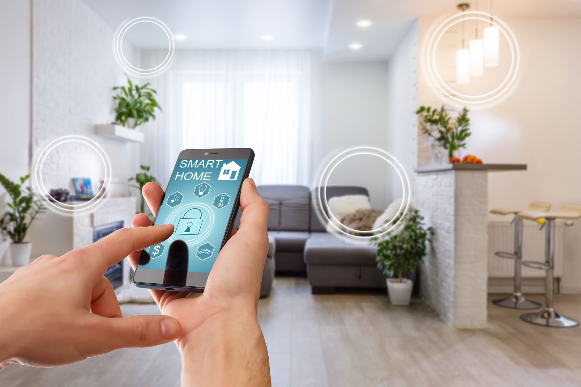A person is holding a smart phone in their hand in a living room.