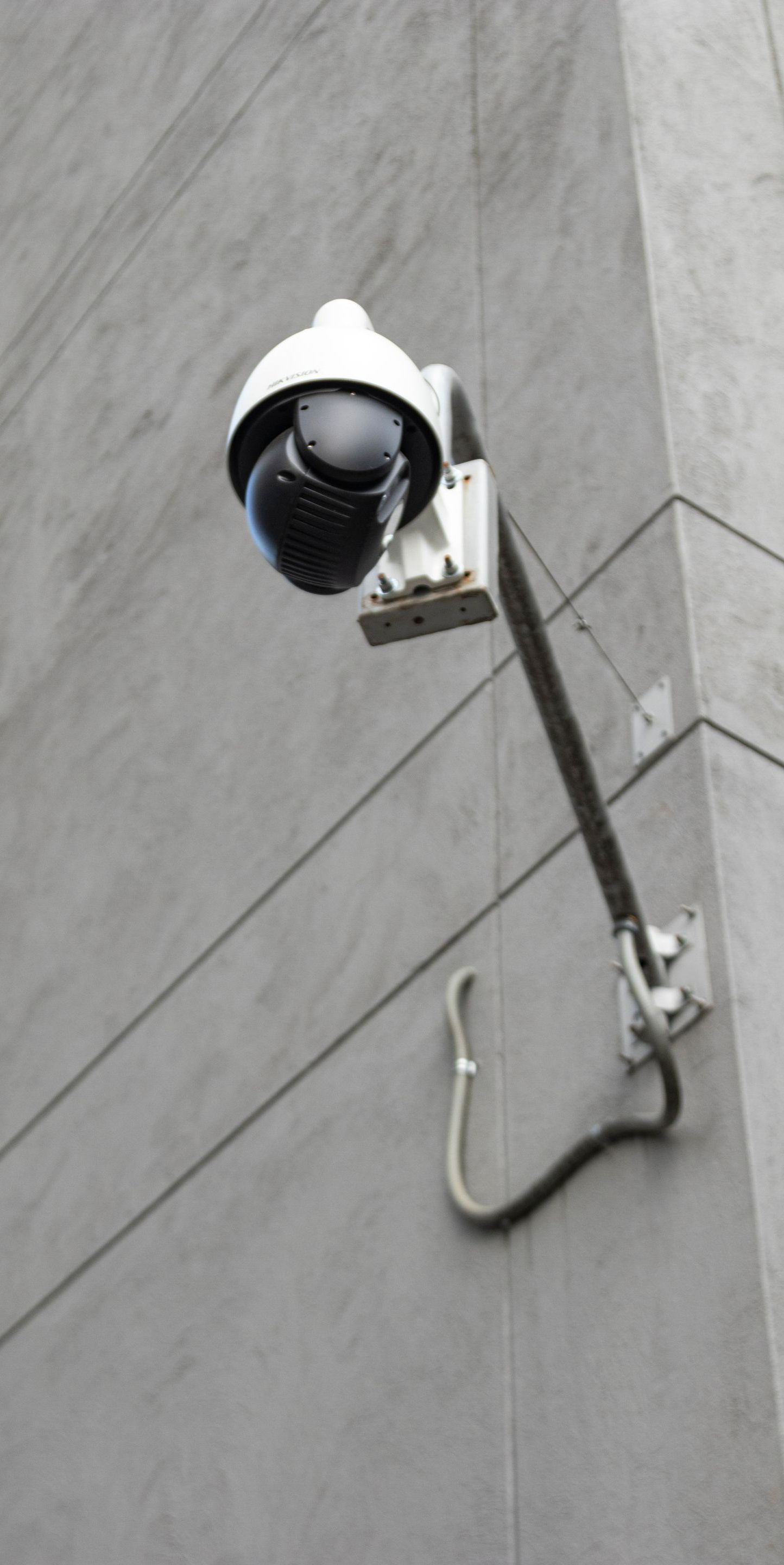 A security camera is mounted on the side of a building.