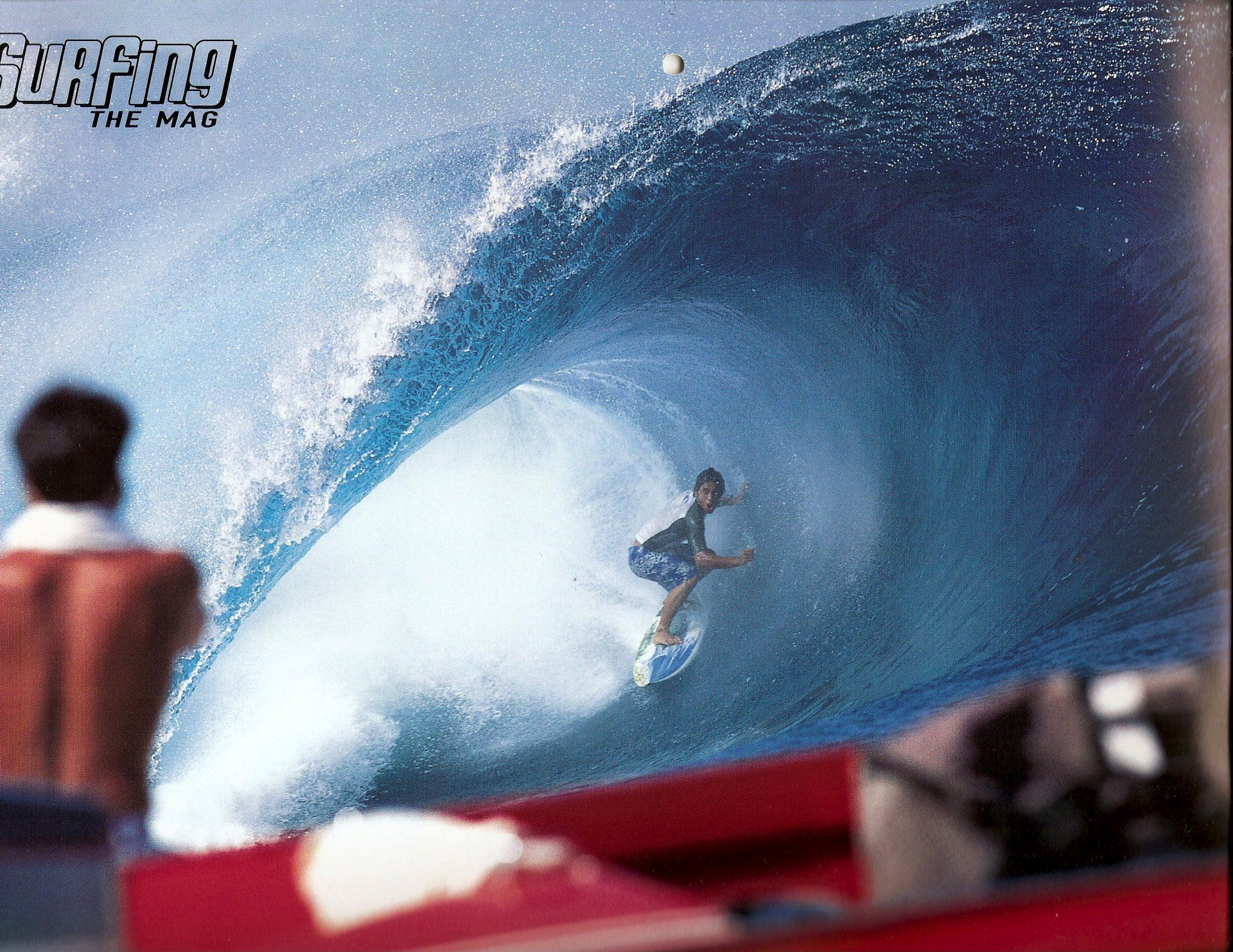 A surfer is riding a wave that says the man on it